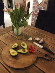 Rund fjøl skjærebrett med avocado og tomater